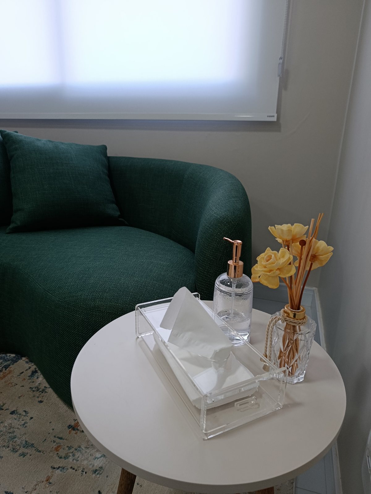 Detalhe da mesa de apoio do consultório com arranjo de flores