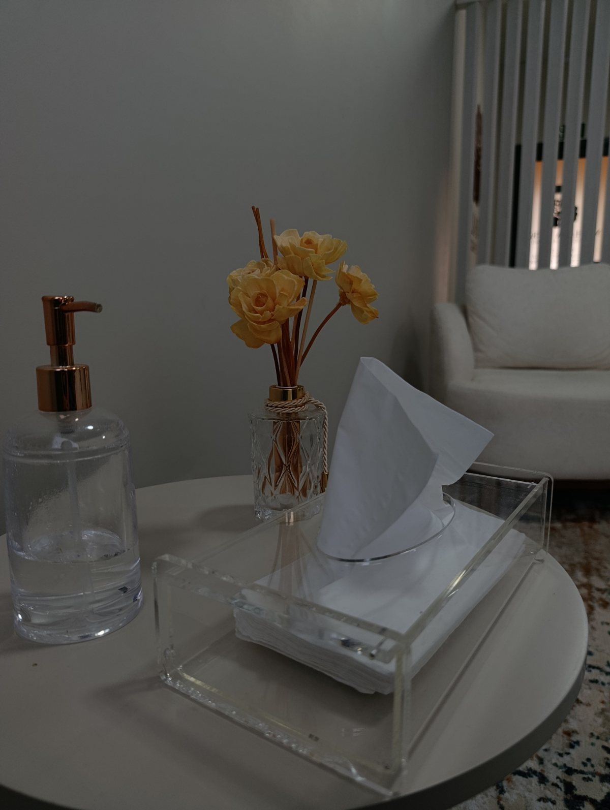 Canto do consultório com poltrona clara e arranjo de flores