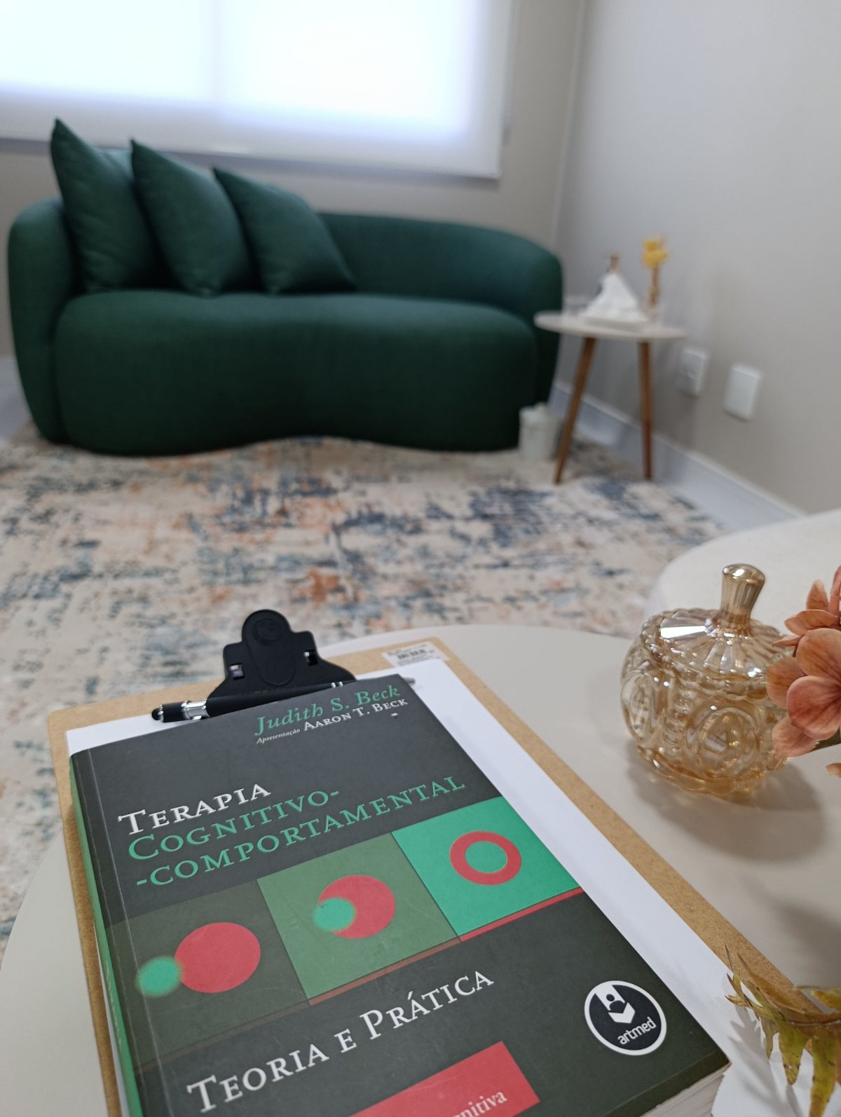 Livro de Terapia Cognitivo-Comportamental sobre a mesa do consultório